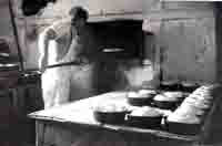 Steve Northover loading bread into the oven at Rendells· bread mill  at ·The Grove·