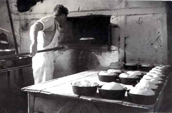 Steve Northover loading bread into the oven 