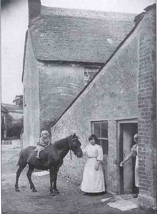 Mr Henry Pout and his daughter outside his Burton Bradstock bakery before 1903, 